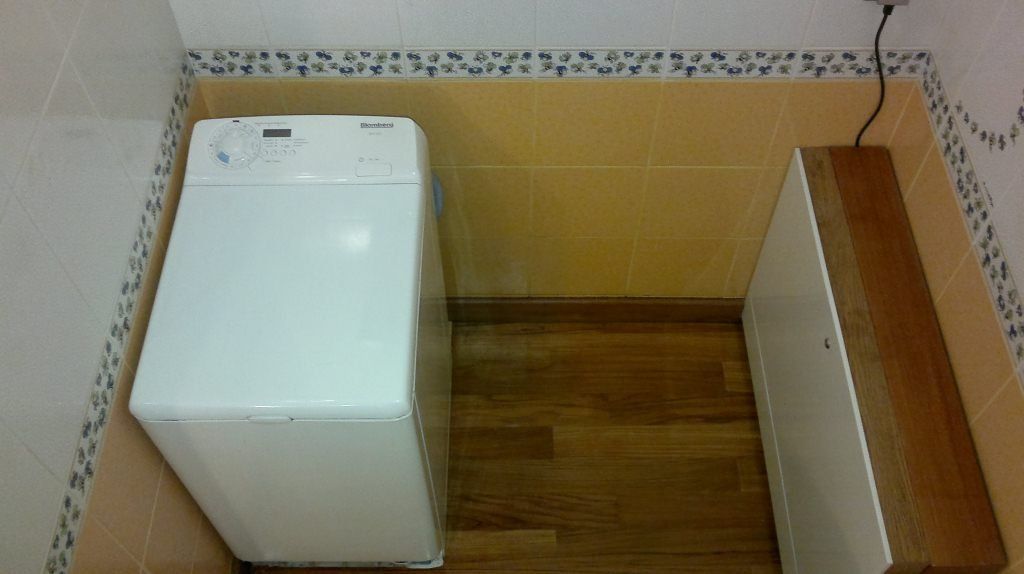 Стиральная машина в интерьере ванной, как и задумано, своими габаритами полностью закрывает опорную площадку, выложенную плиткой.