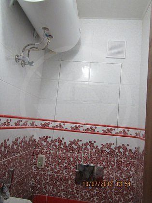 На дизайн туалета фото которого здесь представлено, нисколько не влияет объёмный водонагреватель, надёжно закреплённый под потолком.