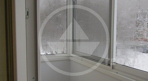 Стены балкона обшиты белыми пластиковыми панелями.