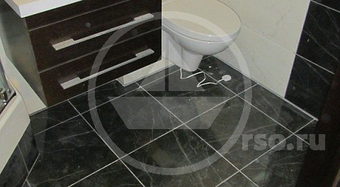 Один из датчиков системы контроля протечки Нептун выведен на пол ванной.