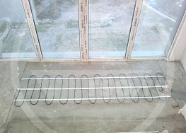 От окна на французский манер демонтирован радиатор и расстелен электрический тёплый пол кабельного типа выполняющий функцию обогрева оконного проёма и не мешающий обзору.